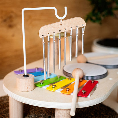 Kind speelt met houten Montessori muziektafel en ontdekt geluiden