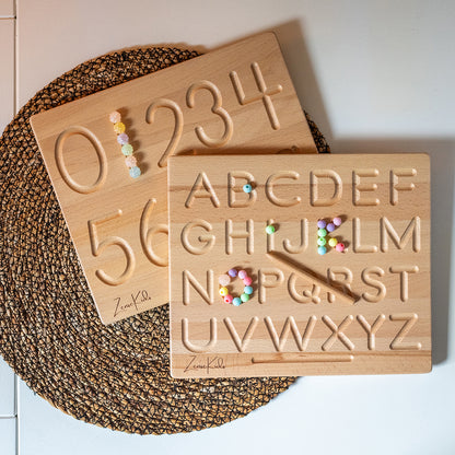 Kind oefent letters op een houten Montessori schrijfbord
